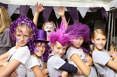 kids with various purple wigs and makeup